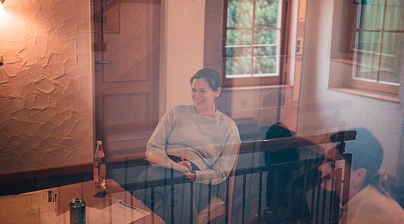 Eine Grafik mit einer lächelnden Personen hinter einer Glasscheibe