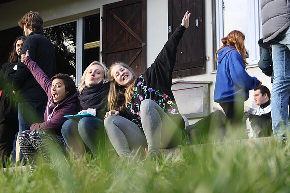 junge Menschen sitzen lachen im Gras