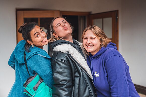 junge Menschen lachende Gesichter offene Türe im Hintergrund