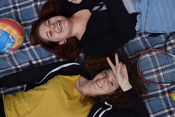 zwei junge Menschen lachen Ball auf einer Decke